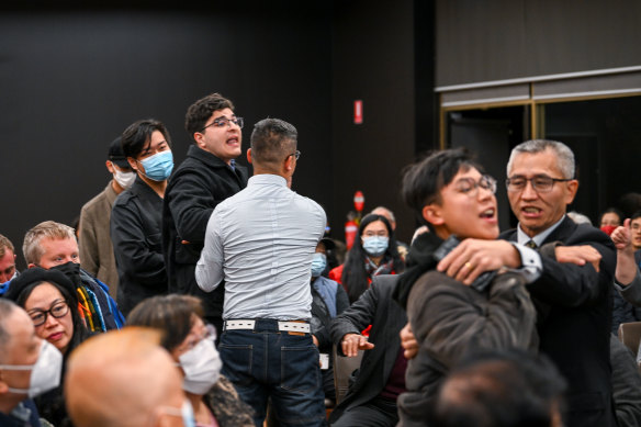 Two men who disrupted the forum are escorted from the hall.