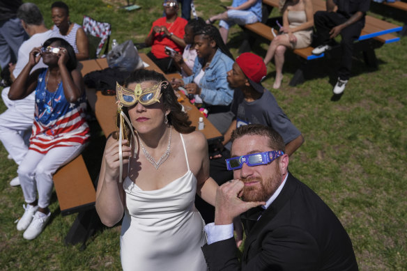 Samantha Palmer, left, and Gerald Lester watch a total solar eclipse before getting married during the event in Trenton, Ohio.