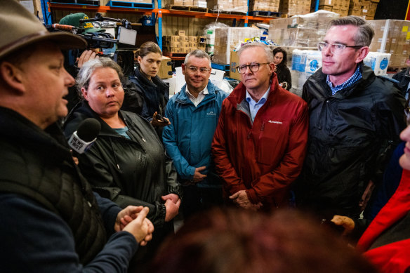 Prime Minister Anthony Albanese and NSW Premier Dominic Perrottet talk to flood victims at a community pantry.
