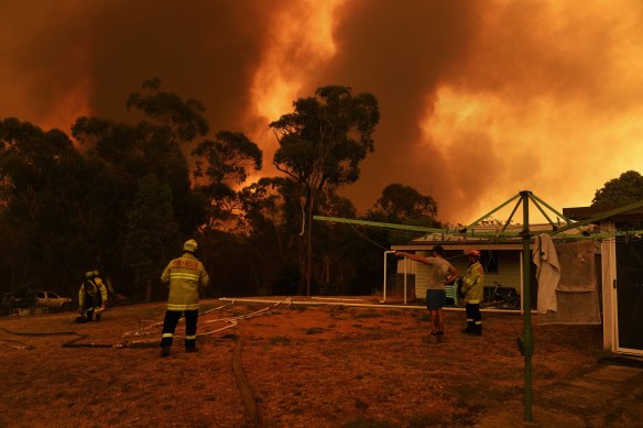 NSW Fire and Rescue firefighters monitor the situation from Luke Dinham's home as the Green Wattle Creek fire approaches Yanderra.