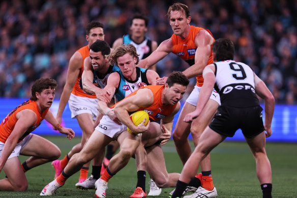 Port Adelaide’s Miles Bergman attempts to tackle Giants star Toby Greene amid the crush on Sunday.
