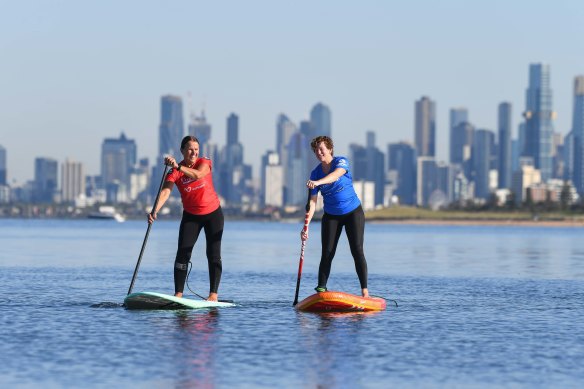 Sharon Bourke (left) teaching Amber Sarda how to paddleboard at Brighton.