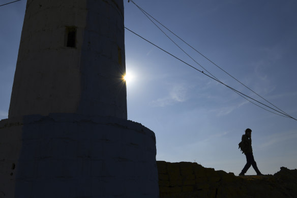 A YPG soldier makes a phone call from a checkpoint between Tal Tamr and Ras al-Ain near the Syria-Turkey border.