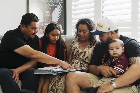 Keith Titmuss’ dad Paul, sister Zara, mother Lafo, brother Jesse and nephew Hudson looking over family photos.