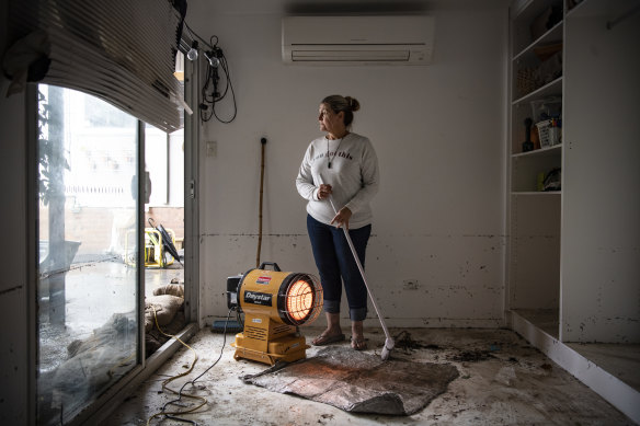 Kate Connell cleans out her flood damaged home after rising waters entered from Peach Tree Creek. 