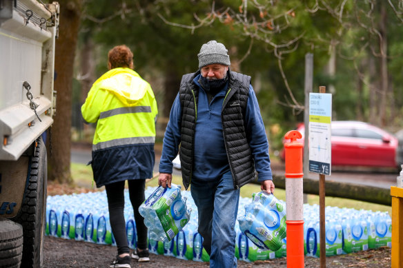 Kallista resident Jeff Seigerman carries bottles of water brought in for residents after they were warned not to drink water from their taps. 