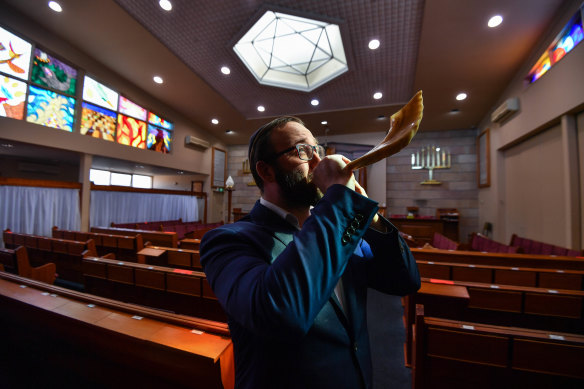 Rabbi Daniel Rabin blows a shofar in his Caulfield South synagogue.