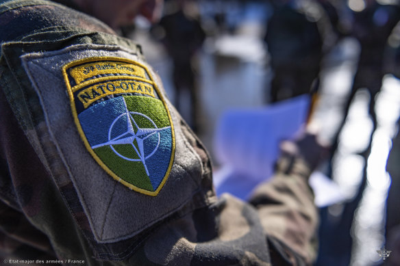 A French soldier from the 7th Mountain Battalion wears a NATO badge at Amari air base, Estonia.