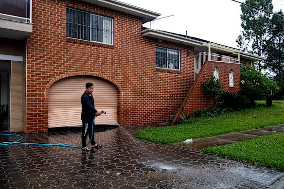 Lansvale resident Paul Huynh hosing down his driveway.