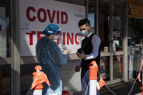 A man speaks to a health care worker at a COVID testing clinic in Campsie on Friday.
