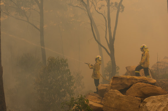 Smoke surrounds firefighters in Hill Top, NSW.