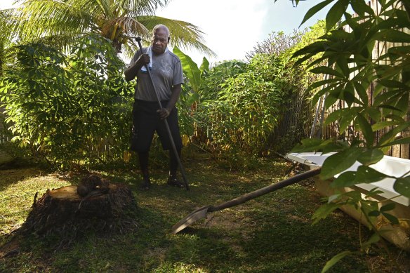 Stanley Cook prepares to dig a hole to plant taro in the backyard of his home on the coastline on Thursday Island.