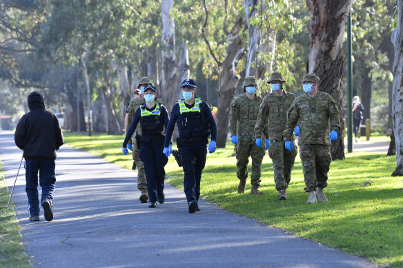 Victorian Police and ADF personnel patrol Princes Park in Carlton on Friday morning. 