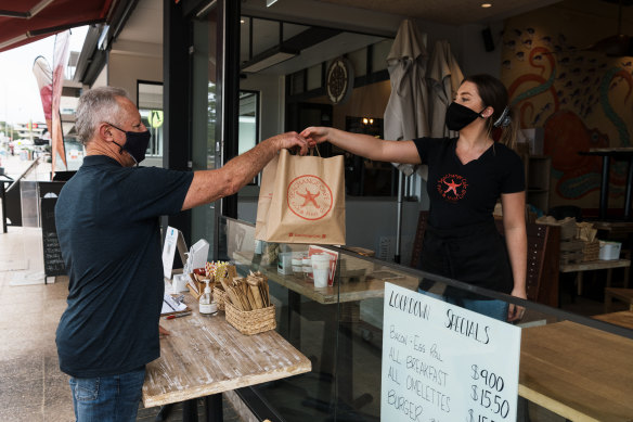 Greg Mullins takes delivery of his take away from Seachange Cafe in Dee Why. 
