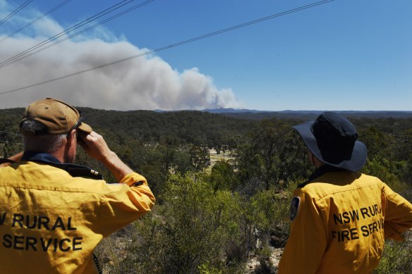 NSW RFS members watch the Gospers Mountain fire move south-east on Thursday.