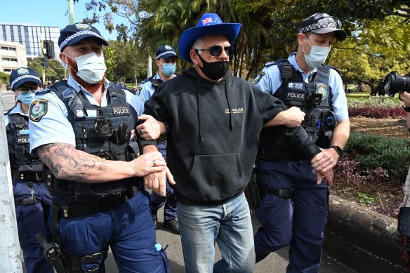 A man in an Australia flag hat is arrested.