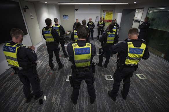Members of Victoria Police Public Order Response Team take part in a pre-shift briefing.