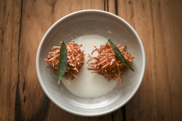 Angel-hair pasta croquette with pumpkin and emmental cheese rests on a moat of buffalo milk.