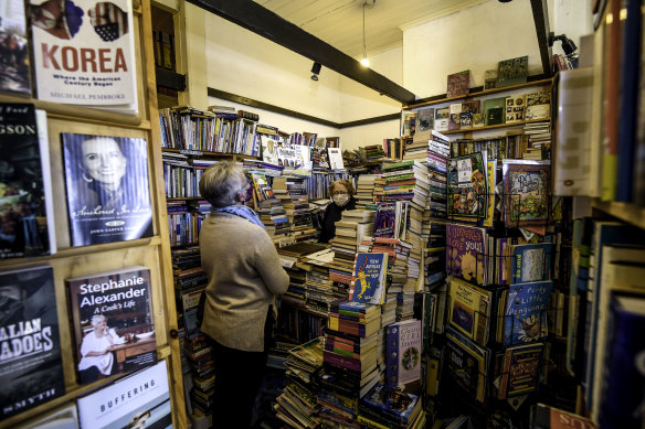 Joyce Saunders serves a customer in her bookshop in Castlemaine, Victoria, after lockdown ended in the regions. 