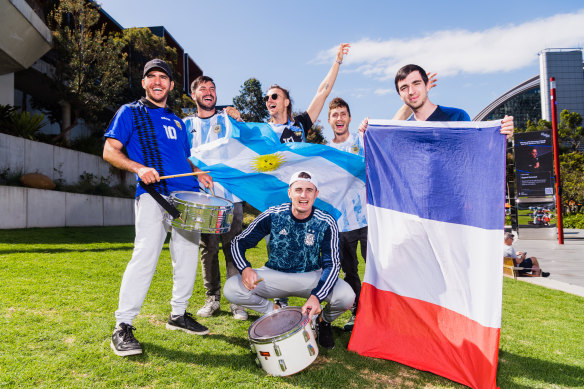 Les fans argentins Facundo Prado, Ivan Dominguez, Danilo Mironescu, Santi Magoya et (à genoux) Mateo Serrano, avec le Français Pierre Durant à Darling Harbour, où les fans se réuniront pour regarder la finale de la Coupe du monde.