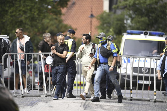 Salwan Momika is escorted by police to a location outside the Iraqi embassy.