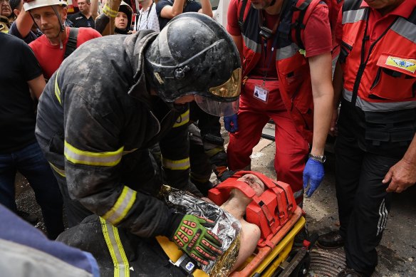 Emergency services rescue Yekaterina Volkova from an apartment building in Kyiv that was hit by a missile attack.