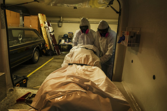 Workers at a Sydney funeral parlour take delivery of the body of a COVID-19 casualty. 
