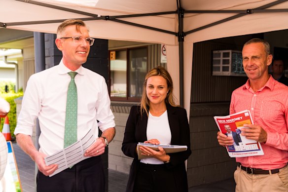 Premier Dominic Perrottet, Liberal candidate for Holsworthy Tina Ayyad and Labor candidate Mick Maroney at a voting booth in Wattle Grove. 