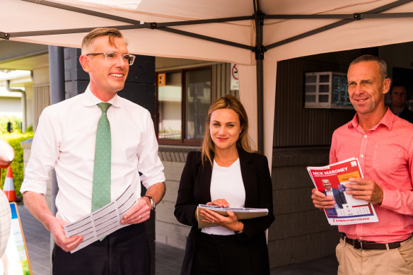 Premier Dominic Perrottet, Liberal candidate for Holsworthy Tina Ayyad and Labor candidate Mick Maroney at a voting booth in Wattle Grove. 