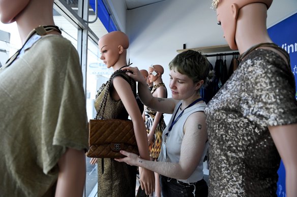  Bianca Hartman hangs a chanel bag on a mannequin in the Newtown Vinnie’s store.