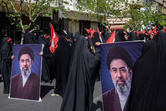 Membri femminili della milizia iraniana Basij portano bandiere e immagini del nuovo leader supremo Mojtaba Khamenei.