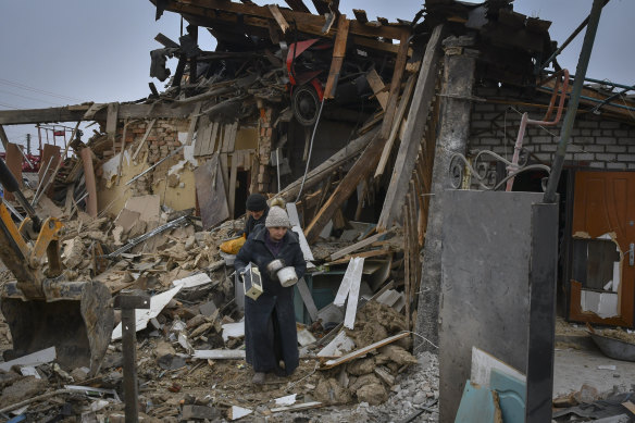 ocal residents carry their belongings as they leave their home ruined in a Russian rocket attack in Zaporizhzhya.