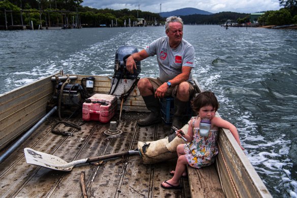 Oyster farmer Rick Christensen with granddaughter Olivia on his punt on the Clyde River in Batemans Bay.