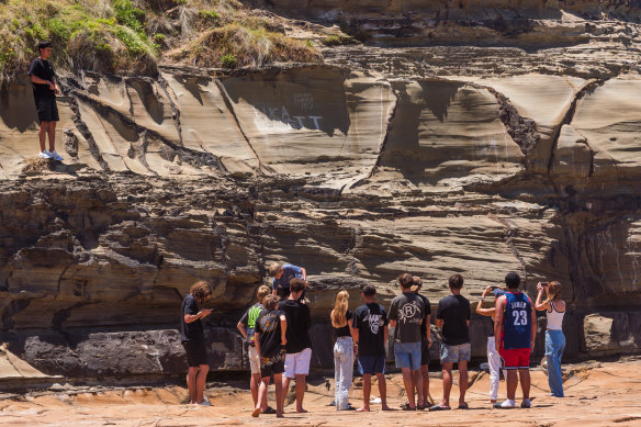 Friends gather on Christmas Day to honour their mate Luca Bennett, who was lost off North Avoca Beach on Tuesday. 