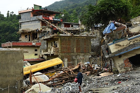 A man amongst debris and destroyed buildings in Betrawoti, which was severely affected by the flash flood.