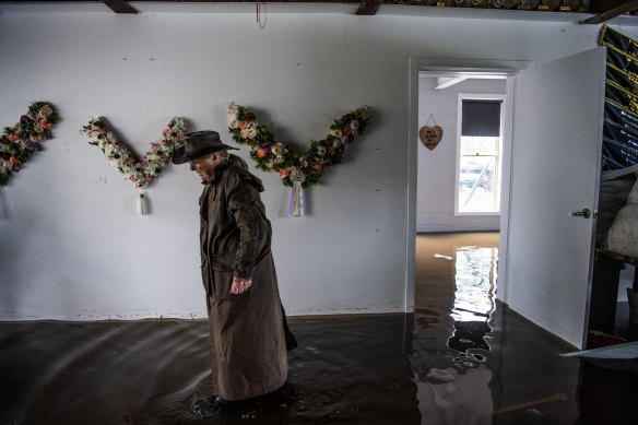 Londonderry resident Janette Shute walks through her friend Leanne Dalrymple’s flooded home on Blacktown Road on Tuesday.