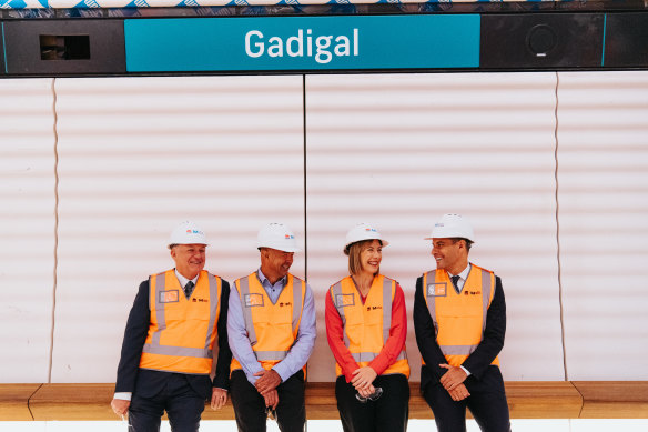 Aboriginal Affairs Minister David Harris, left, Transport for NSW director of Aboriginal engagement George Shearer, Transport Minister Jo Haylen and MP for Sydney Alex Greenwich try out a wooden bench on one of the platforms.