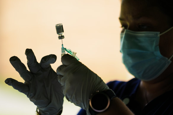 A syringe is prepared with the Pfizer COVID-19 vaccine.