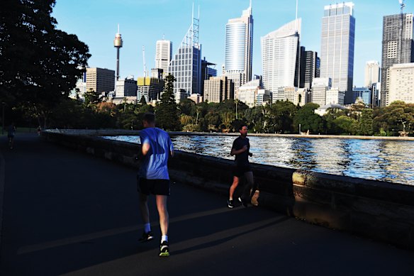 Corredores e caminhantes ao longo do calçadão de Farm Cove. 
