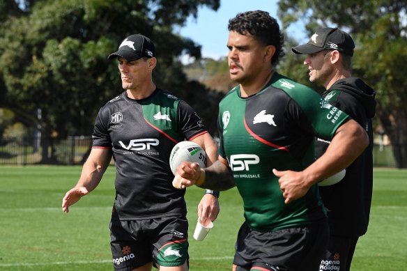 Rabbitohs assistant coaches John Morris and Ben Hornby look at training as Latrell Mitchell jogs by.