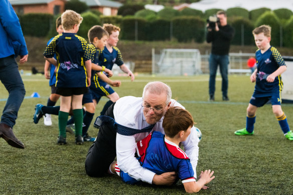Ex-PM Scott Morrison bulldozes a boy while playing soccer with the Devonport Strikers in the electorate of Braddon in May 2022.