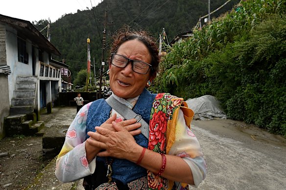 Mendo Lapachi, who lost her brother and two sisters-in-law, reacts to talking of her family and the flood as she gets ready to hold the Ghewa ceremony.