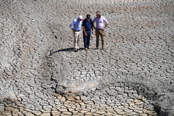 Treasurer Josh Frydenberg, orchard owner Dino Rizzato and Water Resources Minister David Littleproud in a dried-up dam at Cottonvale apple orchard, outside the drought-ravaged town of Stanthorpe, 180km south-west of Brisbane.