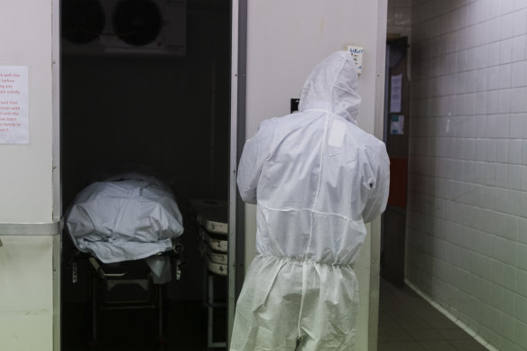 Funeral directors transfer the body of a man who died of COVID-19 into the company's morgue. Despite the protective gear, the funeral director was determined to provide as normal a send off as possible. 