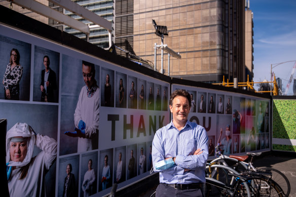 Dr Julian Druce, head of virus identification at the Doherty Institute, outside the Metro Tunnel hoardings where the photo gallery of health workers has been installed. 