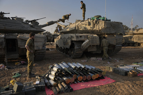 Israeli soldiers load shells onto a tank in southern Israel near the border with Gaza.