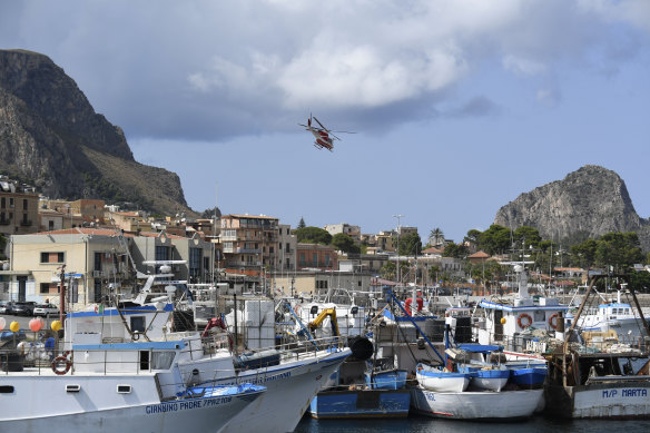 An Italian Firefighters helicopter flies over the harbour of Porticello, southern Italy.