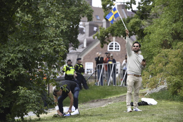Salwan Momika waves the Swedish flag outside the Iraqi embassy in Stockholm in July.