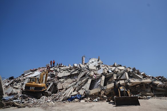 Rescuers work on top of debris from a damaged building in La Guaira.