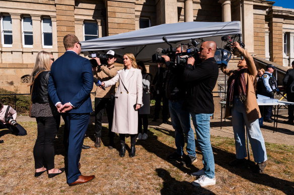 Refusing to answer reporters’ questions, suspended police officer Kristian White and his partner stand outside Cooma Court in September.